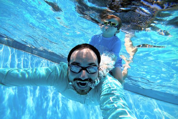 Dad swimming with son underwater